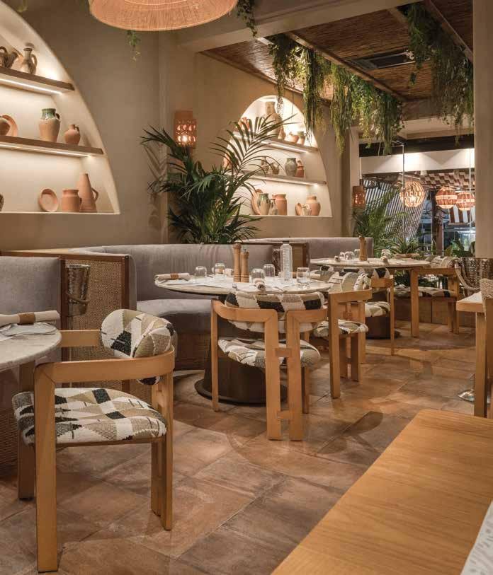 Ahşap sandalye ve masalarla döşenmiş, kemerli bir restoran salonu